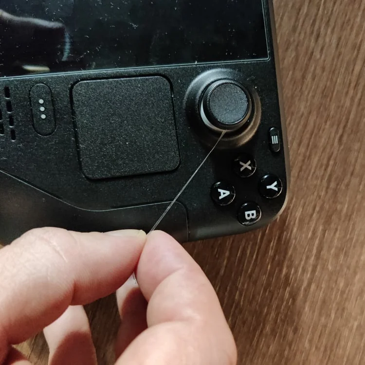 Cutting Scotch Tape to fix sticking joysticks on Steam Deck